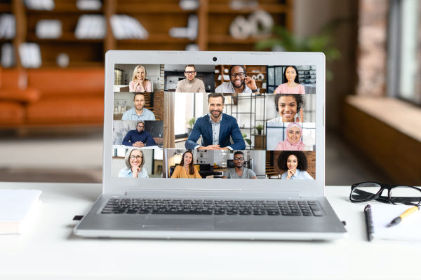 A laptop with an online group meeting on the screen